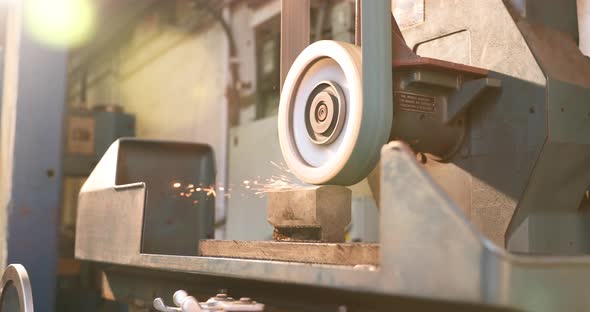 Belt grinder grinding a piece of steel