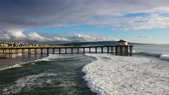 People swimming in the ocean wave. Aerial drone view of coastal Manhattan Beach, California.