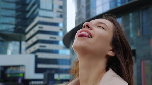 Joyful Girl Sticks Out Tongue to Taste Raindrops