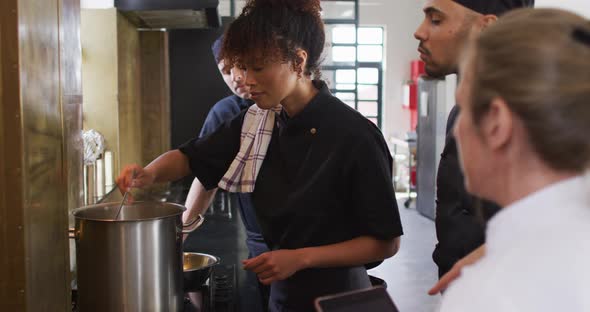 Caucasian female chef teaching diverse group