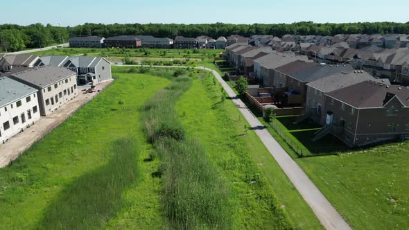 Outdoor paved nature walking path in community neighborhood, day drone aerial