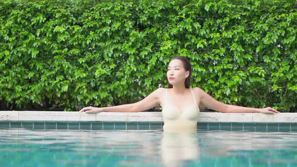 Young asian woman enjoy around outdoor swimming pool for leisure