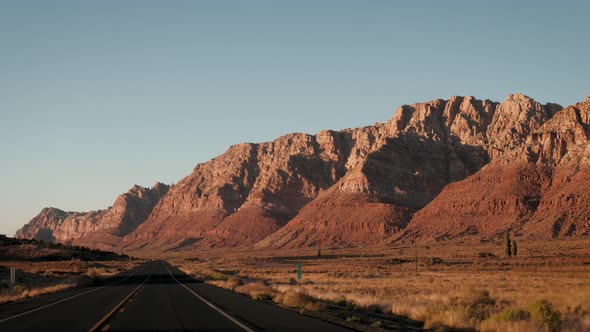 Drive On Highway In Usa Desert Among Rocks At Sunset View From The Vehicle