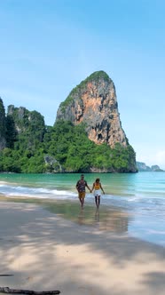 Railay Beach Krabi Thailand Couple Asian Woman and European Men Walking on the Tropical Beach of