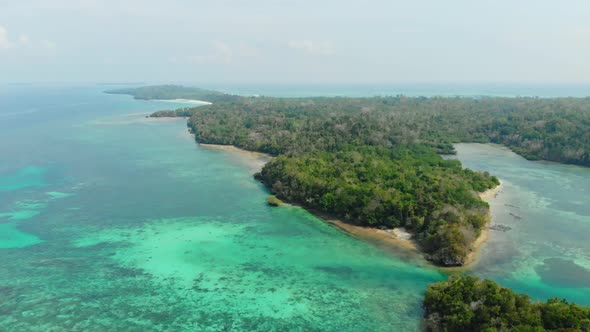 Aerial: uncontaminated coastline tropical beach caribbean sea coral reef atoll