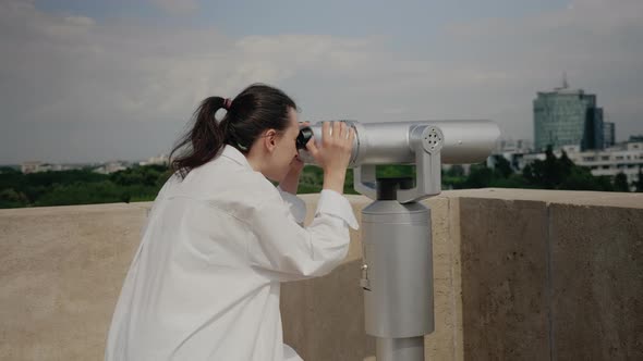 Young Traveler Woman Using Binoculars on Building Roof