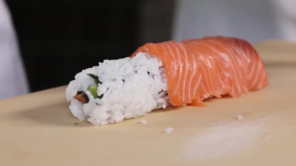 Chef's hands rolling a sushi roll. Sushi making process. Rolls the sushi roll	