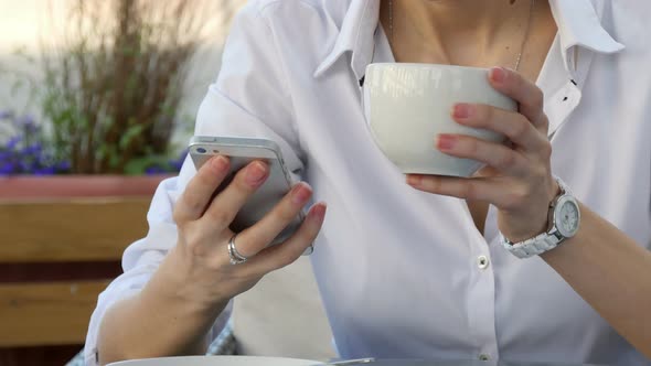 Woman Hand Using a Smart Phone During Breakfast in Cafe with Coffee