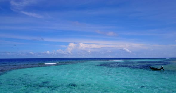 Tropical drone travel shot of a summer white paradise sand beach and blue sea background in vibrant 