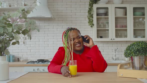 Positive African Woman Speaking on Cellphone at Home