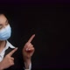 Asian Woman in a Medical Mask Points to an Empty Space for your Advertisement - VideoHive Item for Sale