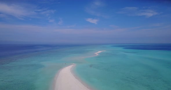 Natural flying abstract shot of a white paradise beach and blue water background in vibrant 4K