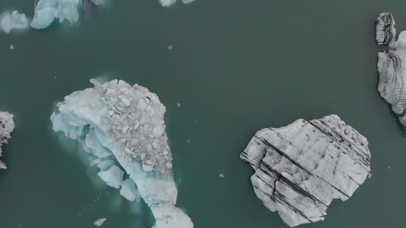 Aerial Drone Ascent Above Icebergs in a Glacial Lagoon.