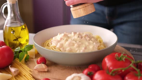 Making Pasta Carbonara  Adding Pepper and Spices to Spaghetti in Ceramic Dish