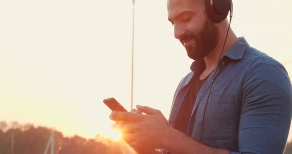 Young Arabian bearded Man chilling and smiling while the Walking Headphones.