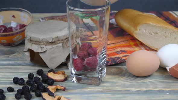 Breakfast. Pouring milk into raspberries