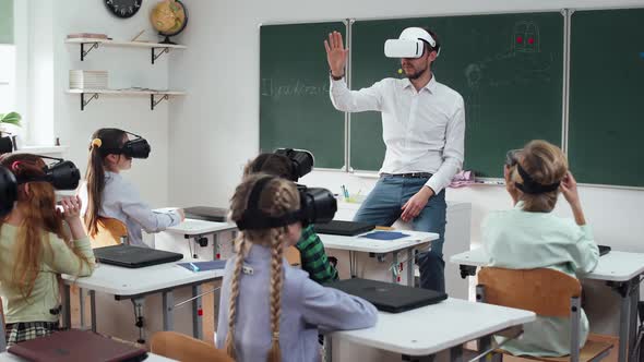 Teacher Teaches an Interactive Lesson at Modern School Childs in Virtual Reality Glasses Learning in