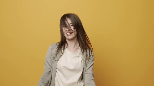 Woman Smiling Dancing to Music Rhythmically to Beat Moving on Yellow Background