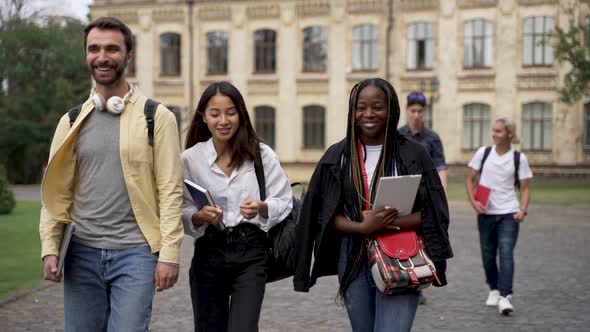 Diverse Classmates Chatting While Walking Outdoors