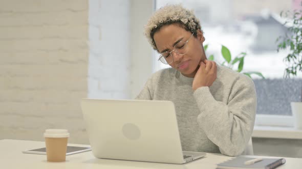 African Woman Having Neck Pain While Using Laptop in Office