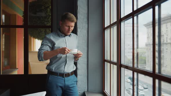 Young man with a cup of coffee in the office