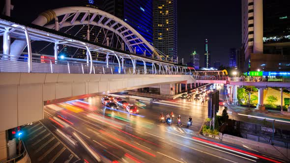 Time-lapse of public sky walk and traffic at Chong Nonsi sky train station at night, Bangkok