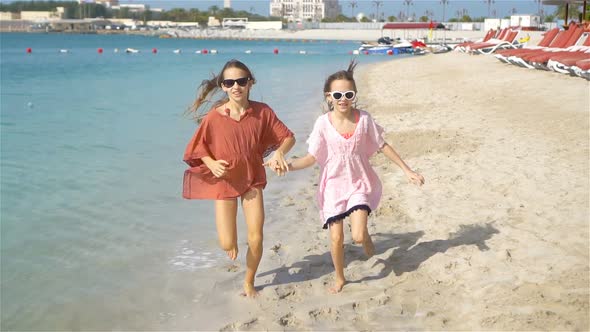 Little Happy Funny Girls Have a Lot of Fun at Tropical Beach Playing Together, Sunny Day with Rain