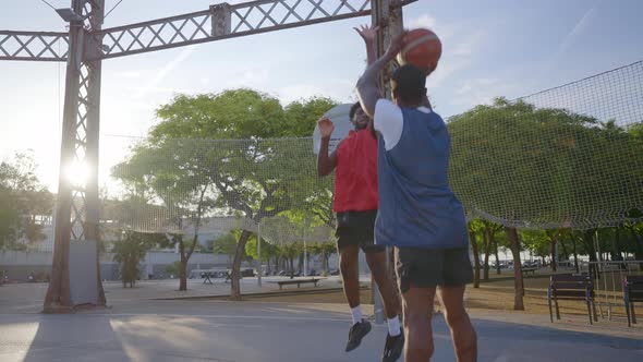 Cinematic footage of a street basketball game outdoor.