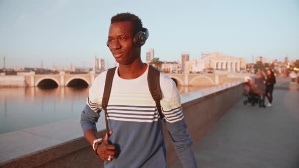 Black Student Walks Around Town at Sunset He's Happy