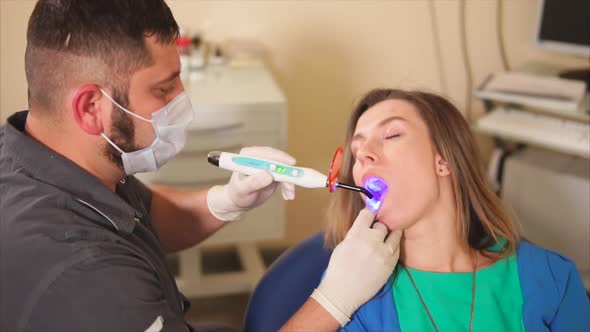 Dentist Using Ultraviolet Lamp on Patients Teeth