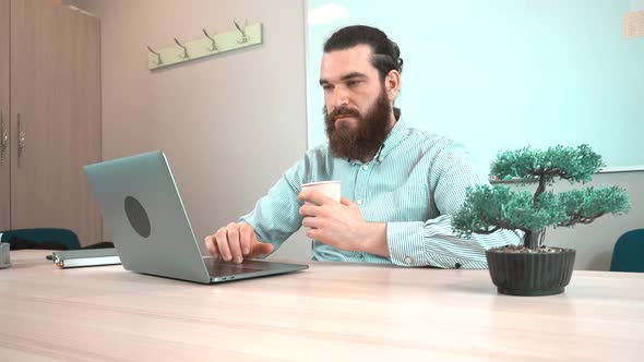 Footage of office bearded man drinking cup of coffee
