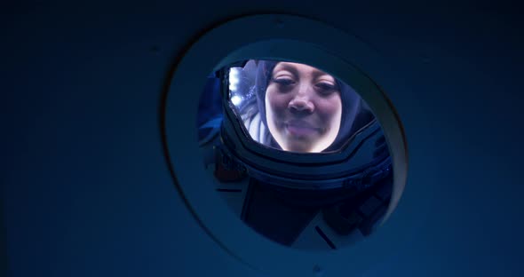 Female Astronaut Looking Out of Spaceship Porthole