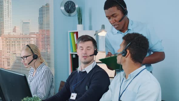 Medium Shot of Multiethnic Customer Service Representative Telling His Colleagues a Joke While