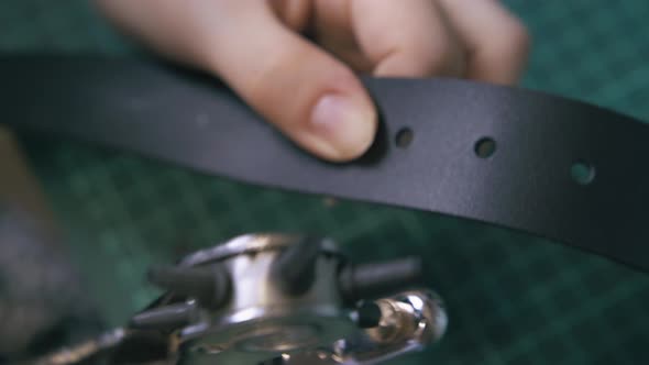 Experienced Worker Makes Holes in Black Leather Belt