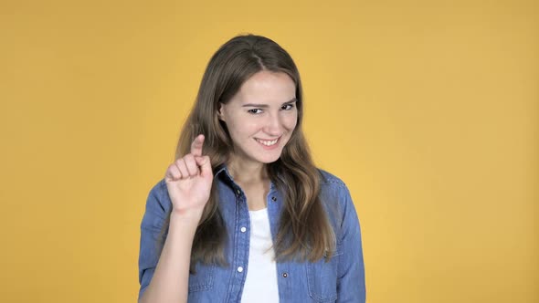 Pretty Woman Pointing at Camera Isolated on Yellow Background