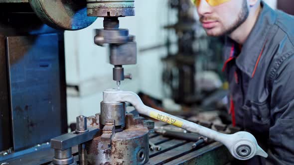 Cutting metal with machine. Worker in factory on the machine