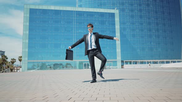 Flexible and cool businessman doing acrobatic tricks outdoor.