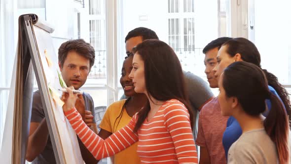 Business executives discussing over on whiteboard