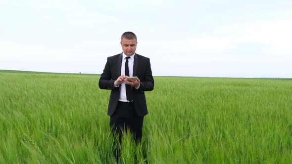 Businesswoman in Suit Inspecting Farmland with Tablet