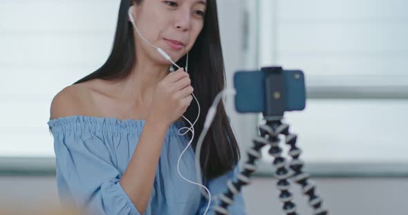 Woman having live stream on cellphone at home