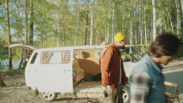 Friends Having Picnic at Campsite in Woods