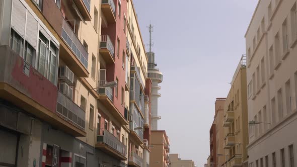 A tower seen from a street with apartment buildings