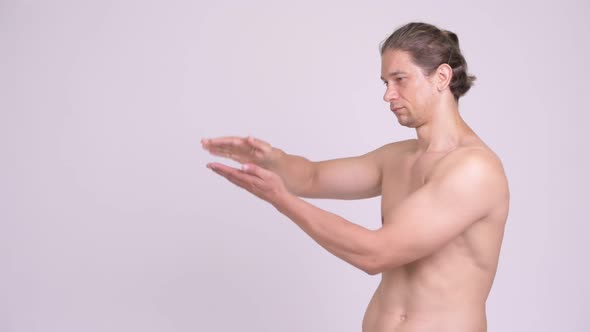 Happy Muscular Shirtless Man Snapping Fingers and Showing Something