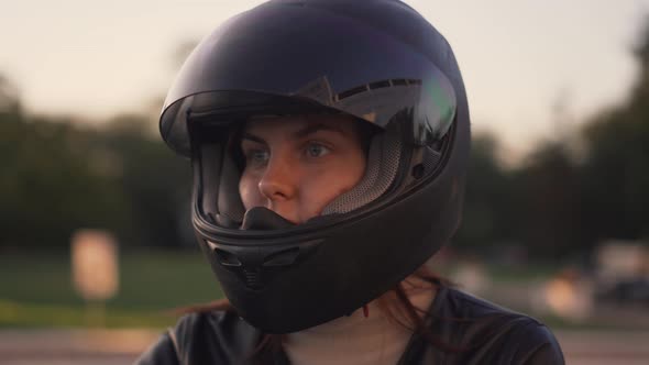 Beautiful Young Redhaired Woman Motorcyclist Sitting on Custom Bike with Black Motorcycle Helmet