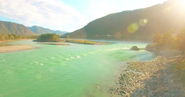 Low Altitude Flight Over Fresh Fast Mountain River with Rocks at Sunny Summer Morning.