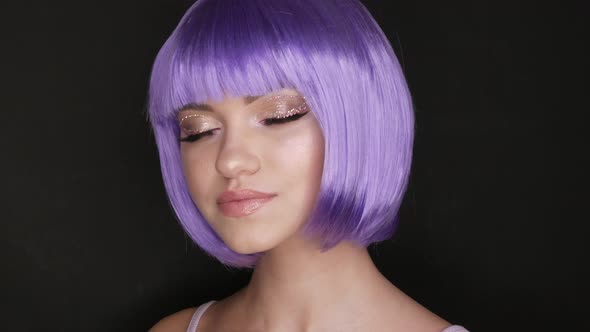 Beautiful Young Girl Model Posing in a Purple Short Bob Wig Rhinestones on Her Eyes and Stylish Pink