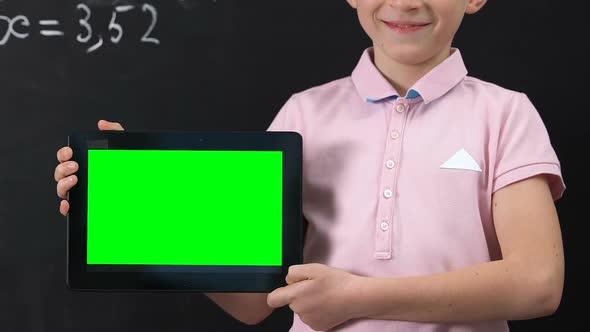 Smiling Schoolboy Holding Tablet PC Wit Green Screen, Online Education Concept