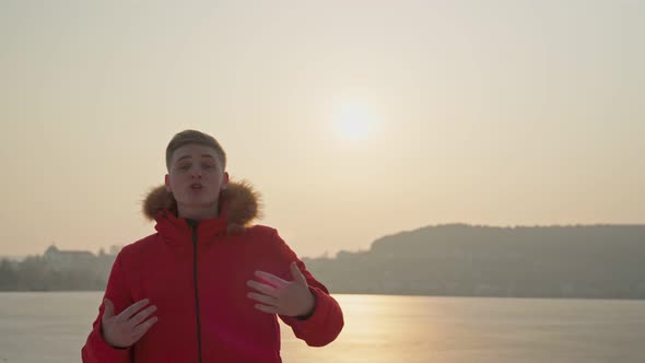 A Guy of the European Race in a Red Jacket Performs a Rap Song