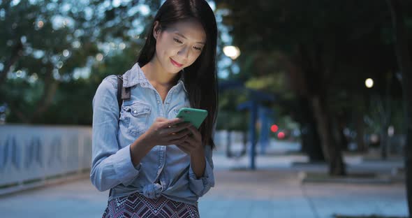 Woman looking at mobile phone in the evening