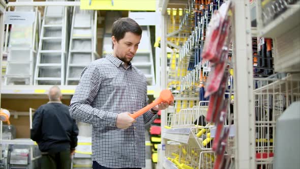 Man in Hardware Store Chooses Tools